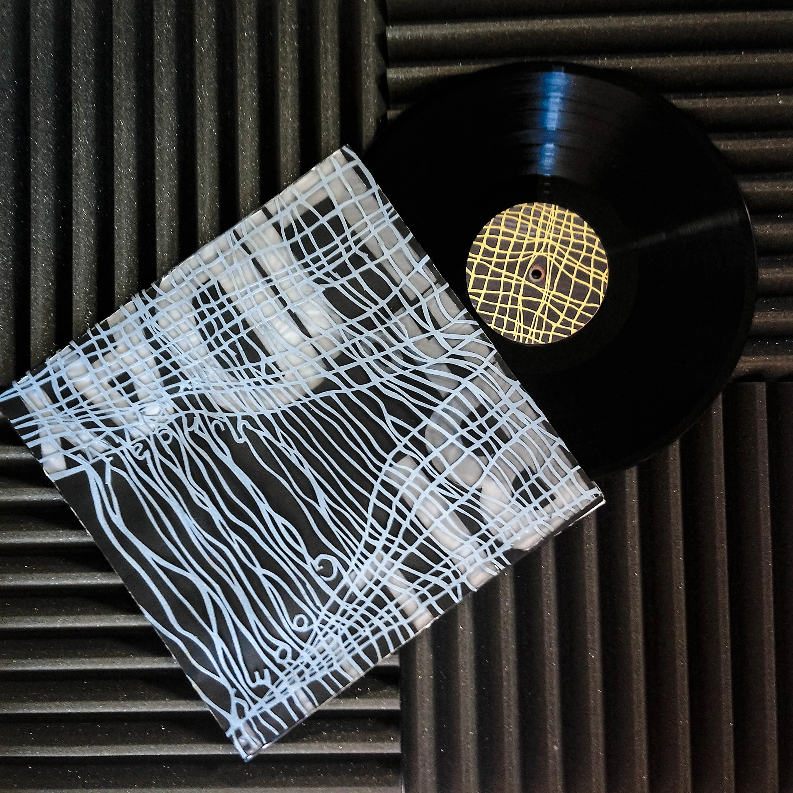 Cover of Billie Holiday's 'Gloomy Sunday' record, featuring a woven pattern on a black background.